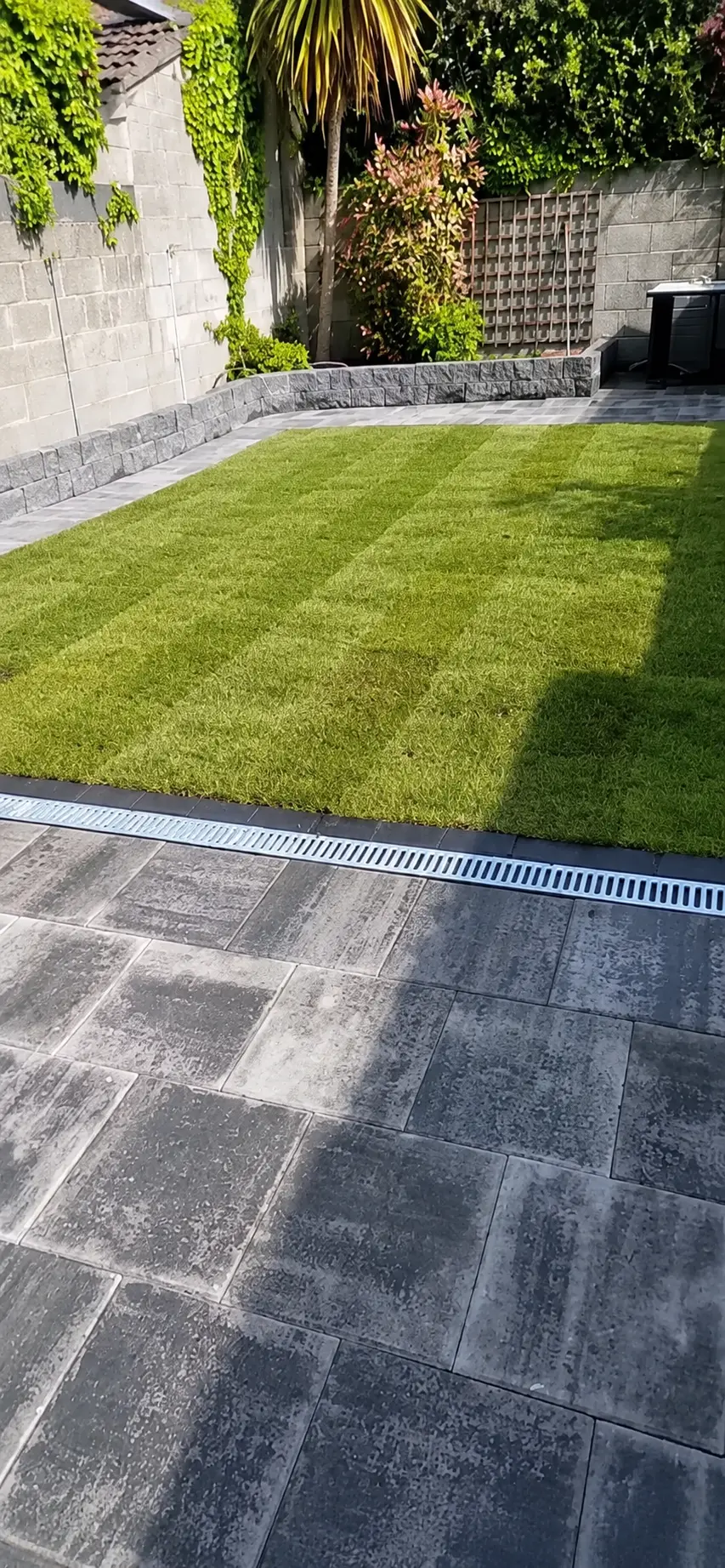 Brick and block paving project in Laois with a drainage channel beside a fresh lawn | Farrell Exteriors